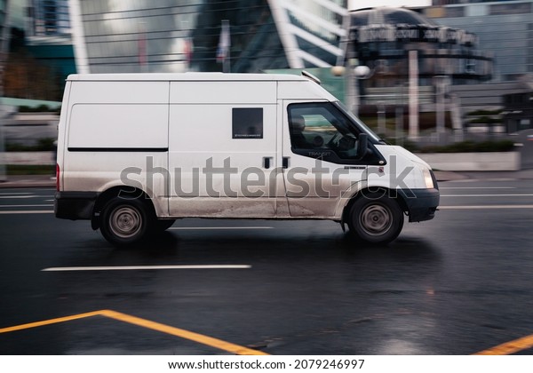 Moscow, Russia -\
October 2021: Ford Transit Third generation van in the city street.\
Side view of white panel van, light commercial vehicle speeding on\
wet, slippery asphalt\
road