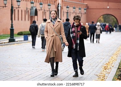 Moscow, Russia - October 2022: Young Couple Walking Down The Street Holding Hands In Alexander Garden, People In Autumn City