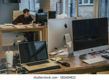 MOSCOW, RUSSIA - OCTOBER 22, 2014: Creative Man Is Working In His Office On Apple Pc Monitor Computer. Laptop Mac Book Pro Stand On Wooden Table. 