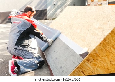 Moscow, Russia - October 23, 2017: Worker Mounts A Bitumen Roof On A Sample. Modern Roofing Materials.