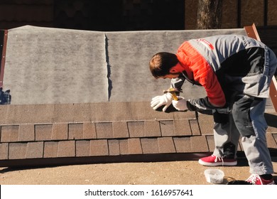 Moscow, Russia - October 23, 2017: Worker Mounts A Bitumen Roof On A Sample. Modern Roofing Materials.