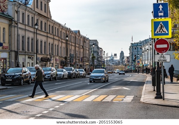 Moscow, Russia - October 3, 2021: Pokrovka is a\
historic street in the center of Moscow. Old Russian architecture.\
Pedestrian crossing through the roadway, bus lane. Autumn in\
Moscow, a sunny day.