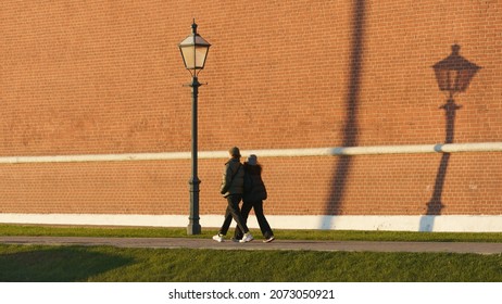 Moscow, Russia - October 31, 2021: People Walking Near The Red Kremlin Wall At Autumn Sunny Day Time. Details Of The Beautiful Medieval Architecture In The Moscow Downtown. Shades Of Street Lantern