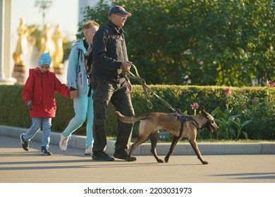 Moscow, Russia - September 10, 2022: Family Walking Dog On The City Street In Autumn Day. Young Dog. Lifestyle Of Big City Concept. Side And Frontal View