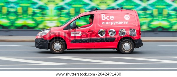 Moscow, Russia - September 2021: Delivery red van of\
the Russian online retailer of tools and instruments Vse\
Instrumenti. Side view of car with VseInstrumenti.ru logo. Courier\
rides on highway road