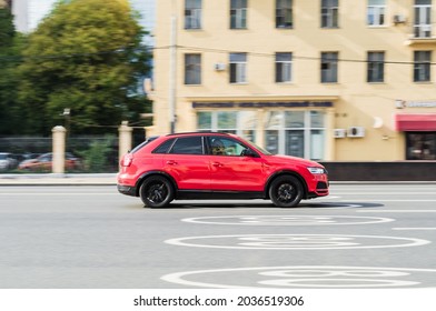 Moscow, Russia - September 2021: Red Audi RS Q3 is driving on high speed with blurred motion in front of classic vintage building