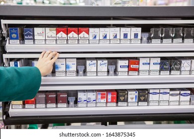 MOSCOW, RUSSIA-CIRCA FEB, 2015: Buyer Hand Stretch To Cigarettes Packs Placed In Special Lockable Box. Laying Out And Demonstration Of Tobacco Products In A Retail Facility Is Prohibited