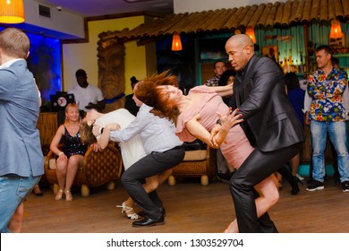 Moscow, Russia-January 19, 2019: A Middle-aged Couple, A Man And A Woman, Dance Salsa Among A Crowd Of Dancing People In A Nightclub Tiki Bar. 