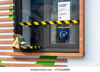 Moscow, Russia-May, 2020:McDonalds offering service through the Drive-Thru due to coronavirus.Order package, cup of coffee in drive-through window.Inscription,translation:we for safety, open 24 hours.