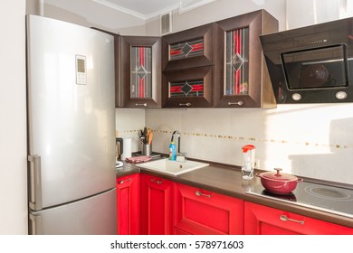 MOSCOW, RUSSIAN FEDERATION - CIRCA FEBRUARY, 2017: The interior of the apartment. Kitchen. Wooden furniture. Cooking panel, cooker hood, washbasin, fridge, utensils.
