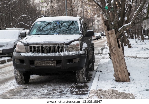 MOSCOW, RUSSIA,NOVEMBER,28.2018:Abandoned snow\
covered car Toyota Land Cruiser on a big city street.Consequences\
of snowfall