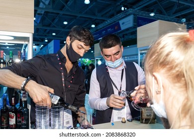 Moscow, Russia,September 21,2021: Two Young Bartenders In Anti-covid Medical Masks Offer Drinks To Customers. Food Business In The Context Of The Covid19 Pandemic.