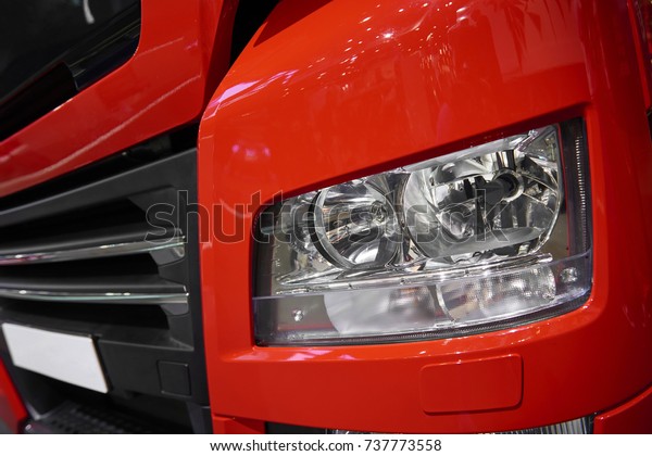 MOSCOW, SEP, 5, 2017: View on red MAN truck front\
light and radiator grille. Commercial Transport ComTrans-2017. Red\
truck light close up. Car light. Truck engine grill hood. Truck led\
light