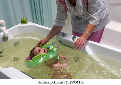 Moskau - September 2014: Ein Mediziner badet ein Baby im Badezimmer. Bezirksärztliche Einrichtung.
