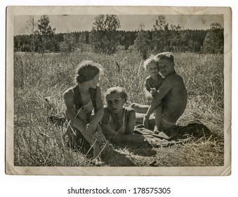 MOSCOW, USSR - CIRCA 1970s : An Antique Photo Shows Family Resting On The Meadow. 