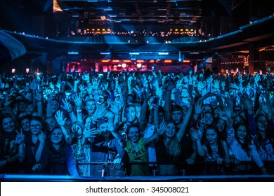 MOSCOW-1 OCTOBER,2015:Concert Crowd Wave Hands On Dance Floor.Music Fans People Have Fun On Edm Dj Festival In Night Club.Young People Partying In Nightclub.Bright Blue Stage Lighting,view From Stage