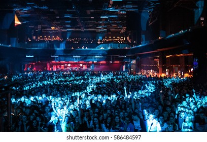 MOSCOW-1 OCTOBER,2015:Crowd Of People On Dance Floor In Music Hall.Crowded Dancefloor In Nightclub Wave Hands.Happy Young People Partying On Rave In Night Club Bright Blue Lights.Pop Musical Concerts