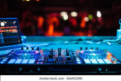 MOSCOW-3 APRIL,2016:dj place on stage in bright blue light.Digital midi controller turn table to mix music.Edm musical festival background.Professional disc jockey stage audio equipment.Play live set