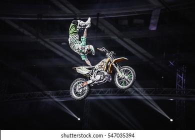 MOSCOW-4 MARCH,2015:Extreme Sport Competition Show.Freestyle Motocross Athlete Jumps High On Big Air Ramp Performing Dangerous Superman Trick With Grab On Motor Bike