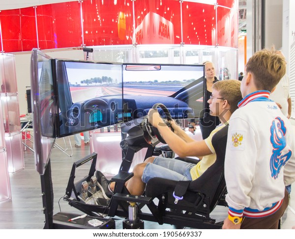 Moscow-August 26, 2016:\
Visitors on the simulator learn to drive a car at the International\
Automobile Salon