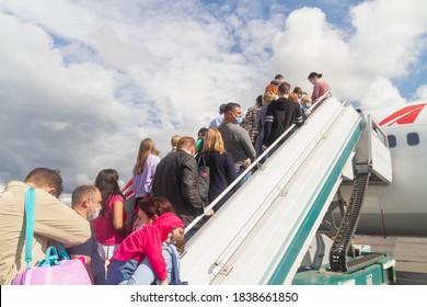 Moscow/Russia - 08 12 2020: The Plane Ramp Is Lowered, People In Medical Masks Climb On The Plane, Without Observing The Social Distance. A Crowd Of People On The Plane Ramp.