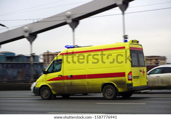 Moscow/Russia - December 11 2019: Crimean bridge.\
The ambulance is in a hurry to call, moving through a traffic jam\
with the light on. Part of the frame is slightly blurred to\
demonstrate the\
speed.