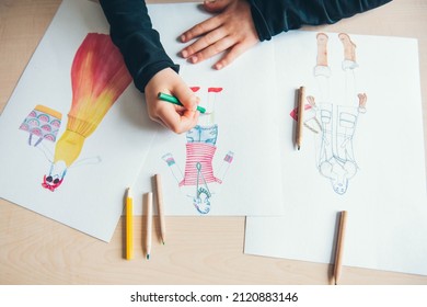 MoscowRussia - February, 02, 2022: The little girl is fond of fashion design. Painting with coloured pencils. Children's creativity.