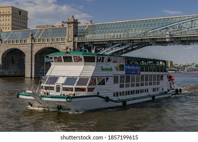 Moscow/Russia; June 22 2019; Touristic boat in the Moscova river, passing under the Pushkinsky bridge (Andreevsky bridge until 1999), in a summer day