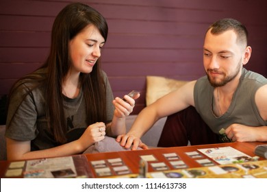 Moskow, 12 June 2018. Couple Playing Board Game At Home. Arkham Horror Game.