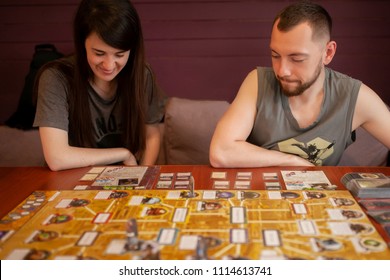 Moskow, 12 June 2018. Couple Playing Board Game At Home. Arkham Horror Game.