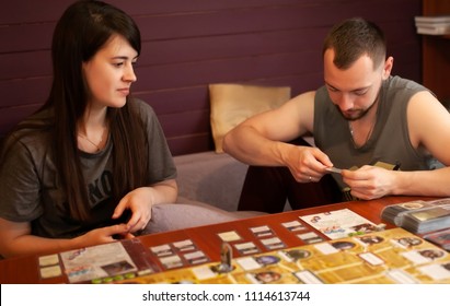 Moskow, 12 June 2018. Couple Playing Board Game At Home. Arkham Horror Game.