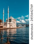 A mosque with a blue sky in the background. Ortakoy Mosque, Besiktas Turkey. A mosque in Istanbul with the bridge in the background.