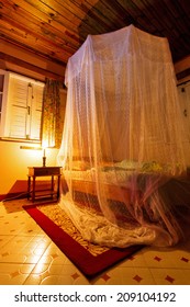 Mosquito Net Over A Bed At Night In The Tropics