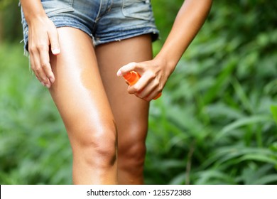 Mosquito repellent. Bug spray anti insects for zika virus in rain forest jungle. Woman spraying insect repellent putting on skin outdoor in nature using spray bottle.