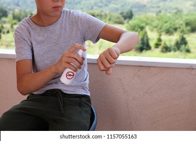 Mosquito Repellent. Kid Using Insect Repellent Spray From Bottle Outdoors.