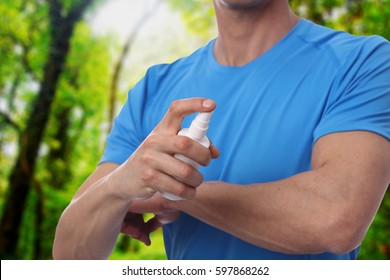 Mosquito Repellent. Man Using Insect Repellent Spray From Bottle In Forest.