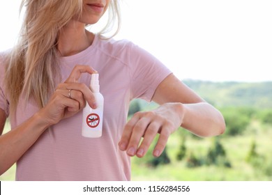 Mosquito Repellent. Woman Using Insect Repellent Spray Outdoors.