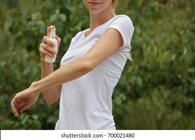 Mosquito Repellent. Woman Using Insect Repellent Spray Outdoors.