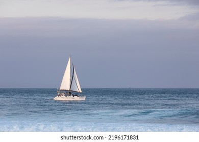 Mossel Bay, South Africa, 2022.05.23 - A Beautiful White Yacht Sails Near The Point At Mossel Bay. The Crew Enjoy The Lovely Views And The Ocean.