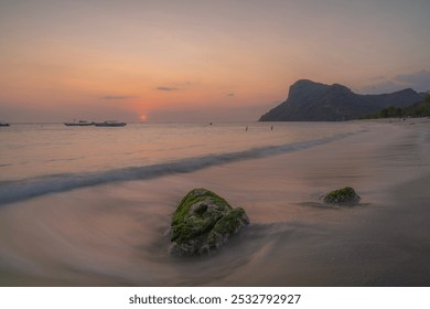 mossy rocks on a beach exposed to the waves at sunset - Powered by Shutterstock