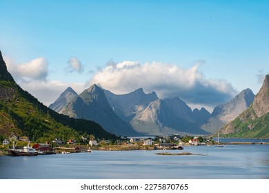 The most famous fishing village Reine with traditional red fisherman's cabins on Lofoten islands, Nordland, Norway. Amazing nature with dramatic mountains and peaks, open sea, pier and bay
