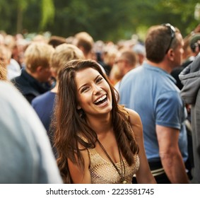 The most fun ever. Portrait of an attractive woman laughing in a crowd at a music festival. - Powered by Shutterstock