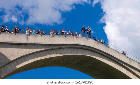 Mostar / Bosnia & Herzegovina - April 2019: Diver Prepares To Jump From Mostar Bridge (Stari Most). Old Mostar Bridge Full Of Tourists.