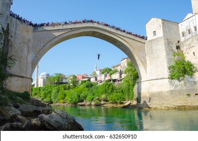 MOSTAR, BOSNIA AND HERZEGOVINA - APRIL 30: Tourists Watch Jump From The Mostar Old Bridge To Neretva River.