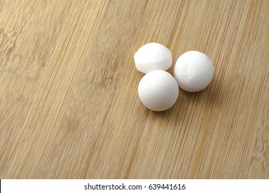 Moth Balls Over The Wooden Board.