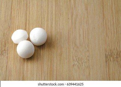 Moth Balls Over The Wooden Board.