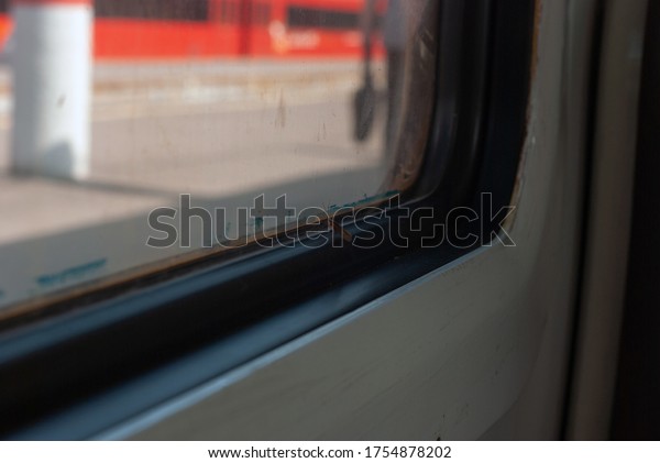 a moth inside a train car. Platform through the\
glass of the train.