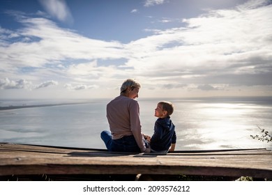Mother and 3 years old son talking to each other having the beautiful ocean view, Portugal