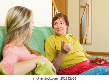 Mother And Adult Daughter Having Serious Conversation On Sofa At Home 