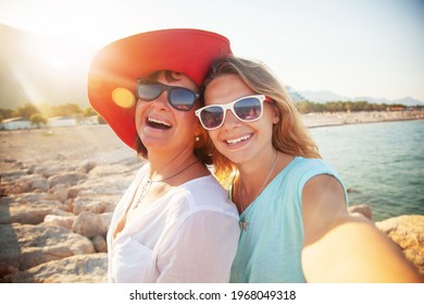 Mother And Adult Daughter Making Selfe On The Beach Traveling Together - Powered by Shutterstock